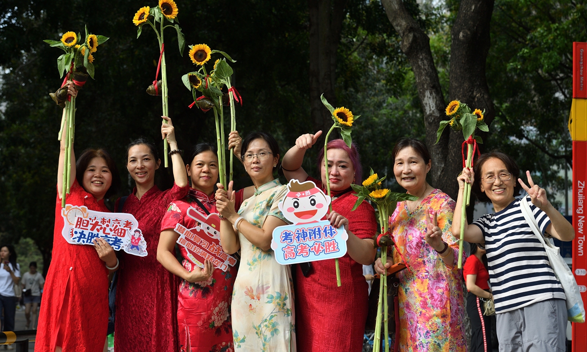 Mothers wearing <em>qipao</em> pose together outside an exam center in Guangzhou, South China's Guangdong Province on June 7, 2023. 