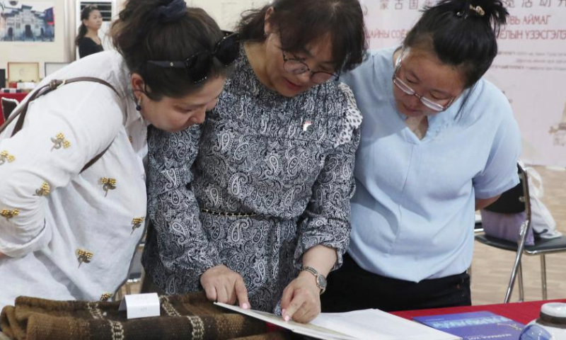 Visitors read a book at a Chinese tea culture exhibition in Sainshand, capital of the southeastern Mongolian province of Dornogovi, June 16, 2023. A Chinese tea culture exhibition opened on Friday here. Various types of tea and tea sets, as well as paintings and books on Chinese tea culture and the ancient Great Tea Road that connects Asia and Europe, are being showcased at the event. (Photo by Suriya/Xinhua)