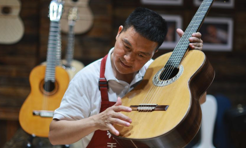 A worker checks a guitar at the Zheng'an Guitar Industrial Park in Zheng'an County, southwest China's Guizhou Province, June 7, 2023.

Zheng'an County is dubbed as a guitar manufacturing center in China. Zheng'an Guitar Industrial Park is an industrial cluster with standardized factories covering over 800,000 square meters and 126 guitar and guitar-related accessories manufacturers. More than six million guitars are produced here annually. (Xinhua/Liu Xu)