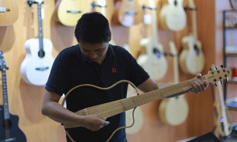 A worker tests a guitar at the Zheng'an Guitar Industrial Park in Zheng'an County, southwest China's Guizhou Province, June 7, 2023.

Zheng'an County is dubbed as a guitar manufacturing center in China. Zheng'an Guitar Industrial Park is an industrial cluster with standardized factories covering over 800,000 square meters and 126 guitar and guitar-related accessories manufacturers. More than six million guitars are produced here annually. (Xinhua/Liu Xu)