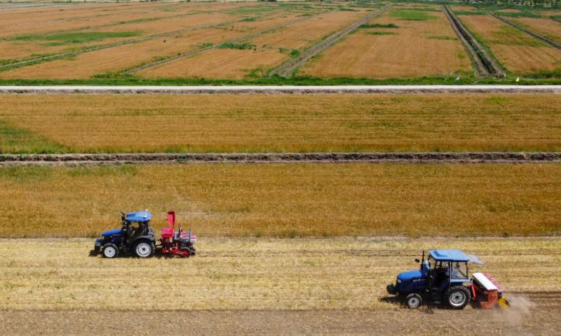 This aerial photo shows machines working during an activity organized by the local goverment to demonstrate agricultural machines in Caigongzhuang Township of Jinghai District, north China's Tianjin, June 11, 2023. Summer harvest in north China's Tianjin has begun. Modern agricultural technology and machinery have been applied in the region to help local farmers increase yield and attain a bumper harvest. (Xinhua/Sun Fanyue)