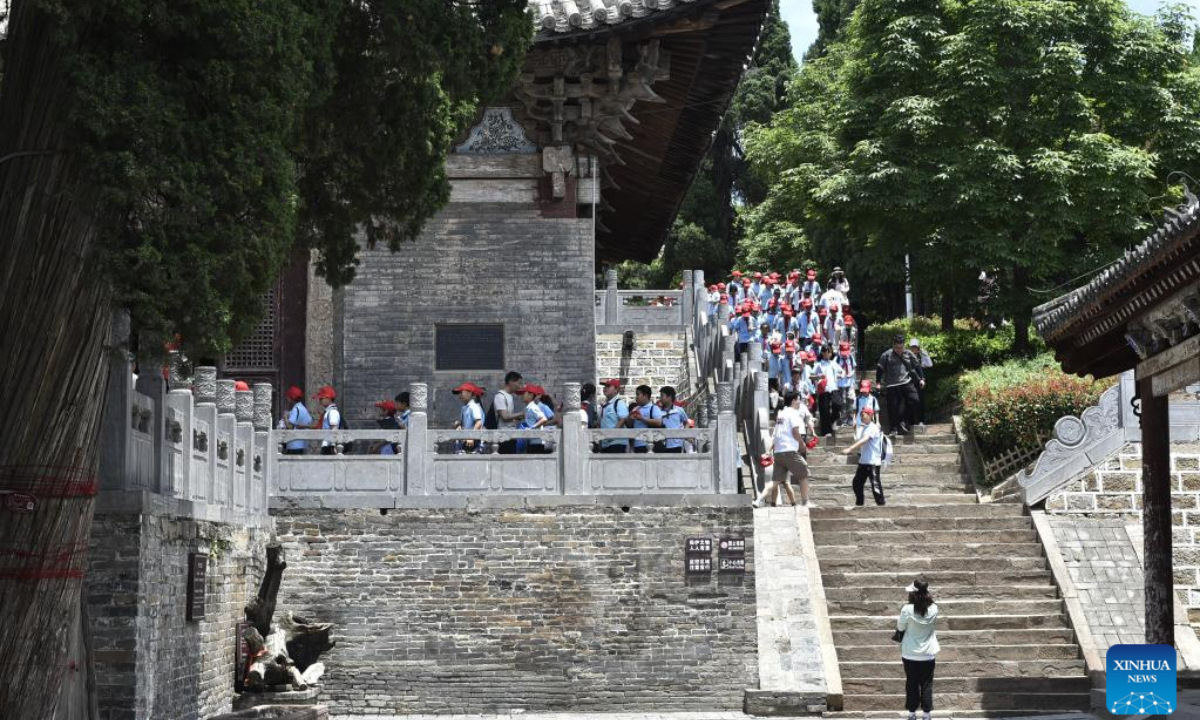 Tourists visit an ancient site in the Wangwu Mountain scenic spot in Jiyuan City, central China's Henan Province, June 15, 2023. Wangwu Mountain is located in Jiyuan City, Henan Province, where the ancient Chinese fable 