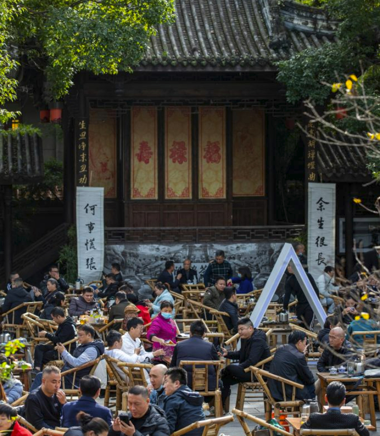 People enjoy their leisure time at an open tea house in Chengdu, southwest China's Sichuan Province, Nov. 23, 2021. Chengdu, a historical city in southwest China's Sichuan Province, is home to treasured cultural and historical sites, including Sanxingdui Ruins, Jinsha Site Museum, and Dujiangyan irrigation system. In recent years, Chengdu has witnessed the rapid development of its cultural and creative industry, showcasing its vitality, creativeness and energy. (Xinhua/Shen Bohan)