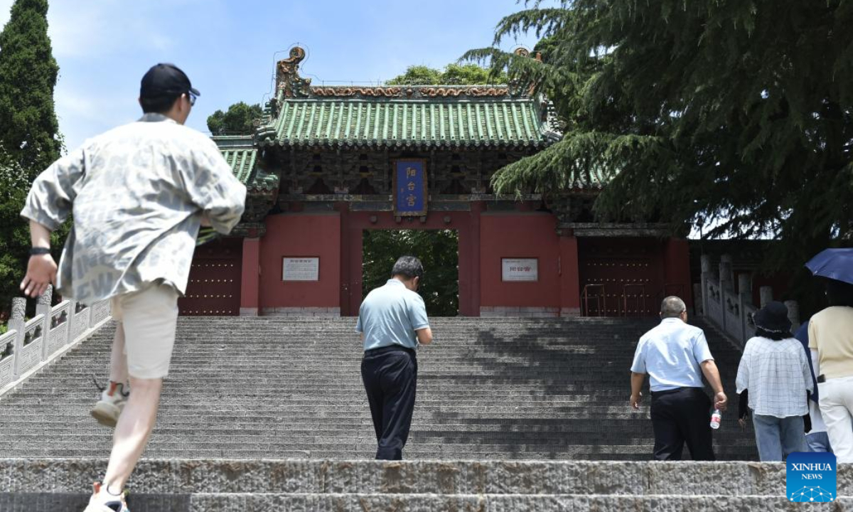 Tourists visit an ancient site in the Wangwu Mountain scenic spot in Jiyuan City, central China's Henan Province, June 15, 2023. Wangwu Mountain is located in Jiyuan City, Henan Province, where the ancient Chinese fable 