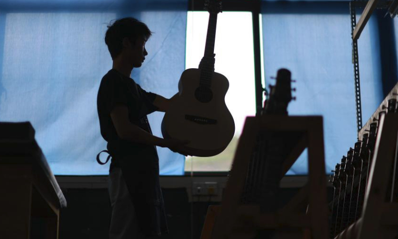 A worker makes a guitar at the Zheng'an Guitar Industrial Park in Zheng'an County, southwest China's Guizhou Province, June 7, 2023.

Zheng'an County is dubbed as a guitar manufacturing center in China. Zheng'an Guitar Industrial Park is an industrial cluster with standardized factories covering over 800,000 square meters and 126 guitar and guitar-related accessories manufacturers. More than six million guitars are produced here annually. (Xinhua/Liu Xu)