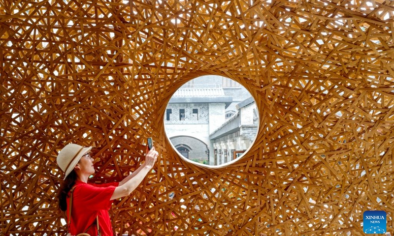 A tourist takes photos in Chongqing's Opening Port Heritage Park in southwest China's Chongqing, June 9, 2023. A three-floor western building covered by traditional Chinese roof ridges glimmers in Chongqing's Opening Port Heritage Park on the south bank of Yangtze River in southwest China's Chongqing Municipality.(Photo: Xinhua)