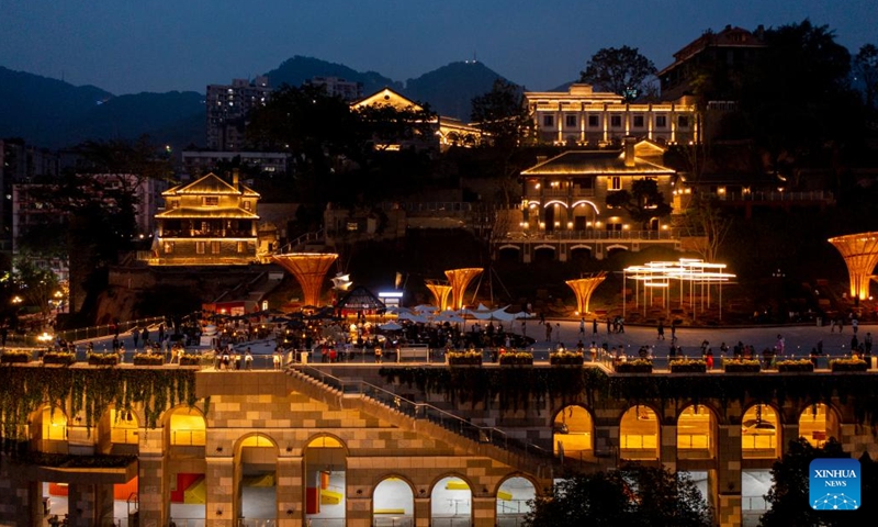 This aerial photo shows tourists enjoying the night view in Chongqing's Opening Port Heritage Park in southwest China's Chongqing, June 9, 2023. A three-floor western building covered by traditional Chinese roof ridges glimmers in Chongqing's Opening Port Heritage Park on the south bank of Yangtze River in southwest China's Chongqing Municipality.(Photo: Xinhua)