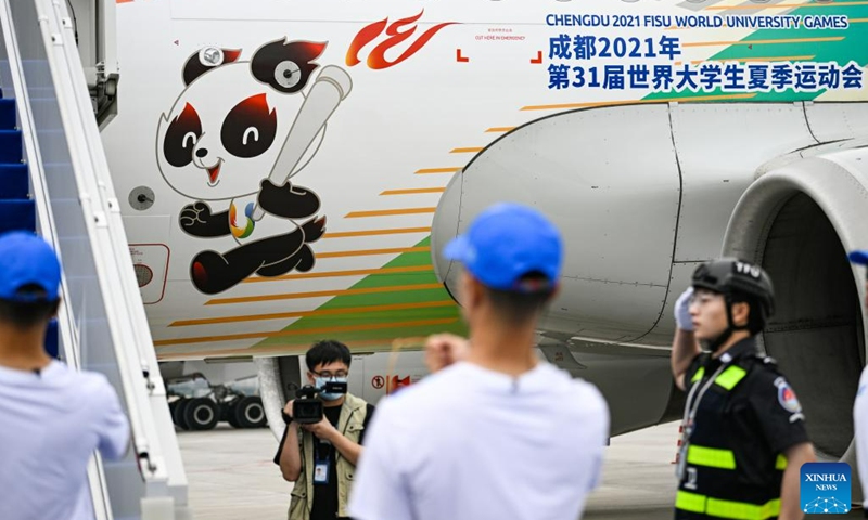 Staff members carry the World University Games flame to the plane at the Chengdu Tianfu International Airport in Chengdu, southwest China's Sichuan Province, on June 8, 2023. The launch ceremony of the torch relay for the 31st FISU Summer World University Games was held at the Chengdu Tianfu International Airport on Thursday.(Photo: Xinhua)