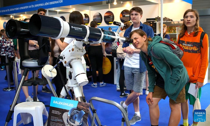 A visitor looks at an object through an astronomical telescope at the Science Fair in Prague, the Czech Republic, on June 8, 2023. The Science Fair, organized annually by the Academy of Sciences of the Czech Republic, is held from June 8 to June 10 this year.(Photo: Xinhua)