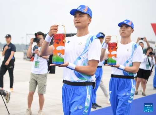 Staff members carry the World University Games flame to the plane at the Chengdu Tianfu International Airport in Chengdu, southwest China's Sichuan Province, on June 8, 2023. The launch ceremony of the torch relay for the 31st FISU Summer World University Games was held at the Chengdu Tianfu International Airport on Thursday.(Photo: Xinhua)