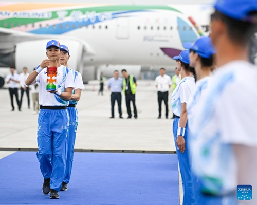 Staff members carry the World University Games flame to the plane at the Chengdu Tianfu International Airport in Chengdu, southwest China's Sichuan Province, on June 8, 2023. The launch ceremony of the torch relay for the 31st FISU Summer World University Games was held at the Chengdu Tianfu International Airport on Thursday.(Photo: Xinhua)