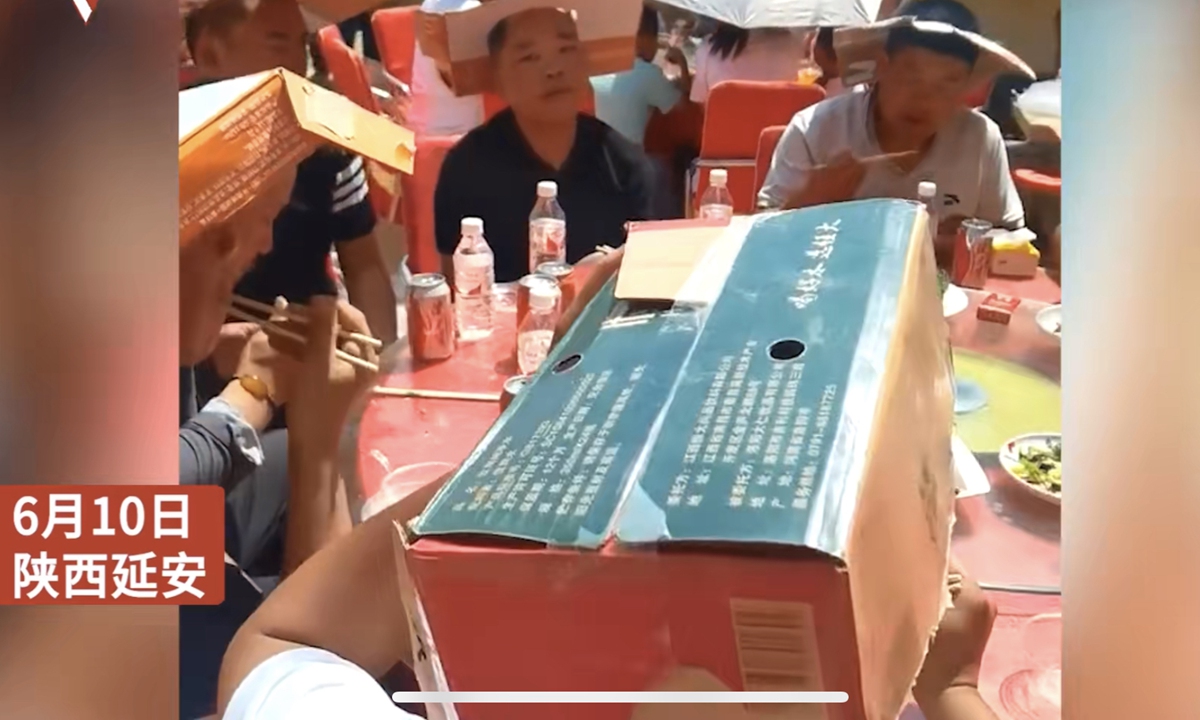 High temperatures and scorching sunshine at an outdoor wedding banquet in Yan'an, Northwest China's Shaanxi Province, prompted guests to make handmade sun hats out of cardboard boxes to alleviate the sweltering heat.Photo:Toutiao News

