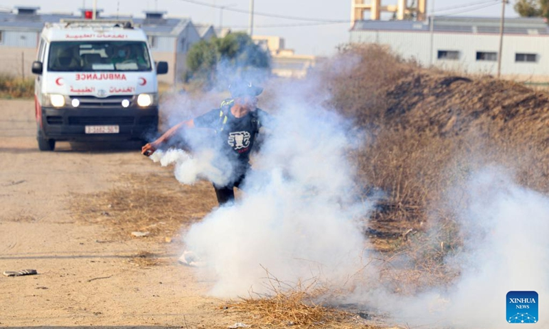 A Palestinian protester throws a tear gas canister fired by an Israeli soldier during a protest against the killing of five Palestinians near the fence of the Gaza-Israel border, east of Gaza City, on June 19, 2023.(Photo: Xinhua)