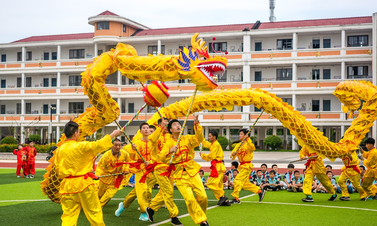 Students observe dragon dance performance in Changxing county, East China's Zhejiang Province, on June 19, 2023. Photo: IC