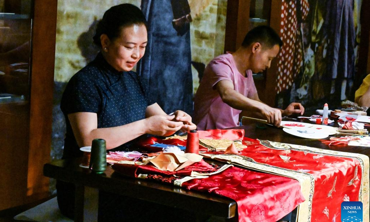 Chen Yuqiu makes sachets at the Jilin Museum in Jilin, northeast China's Jilin Province, June 19, 2023. Chen Yuqiu, 55 years old, is an inheritor of the national-level intangible cultural heritage of Manchu cheongsam making. In order to make people aware of the traditional Chinese culture and Manchu cheongsam, she taught people to make sachets at the Jilin Museum and sent them to citizens before the Dragon Boat Festival. (Xinhua/Yan Linyun)

