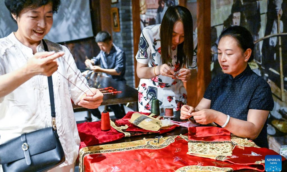 Chen Yuqiu teaches people to make sachets at the Jilin Museum in Jilin, northeast China's Jilin Province, June 19, 2023. Chen Yuqiu, 55 years old, is an inheritor of the national-level intangible cultural heritage of Manchu cheongsam making. In order to make people aware of the traditional Chinese culture and Manchu cheongsam, she taught people to make sachets at the Jilin Museum and sent them to citizens before the Dragon Boat Festival. (Xinhua/Yan Linyun)

