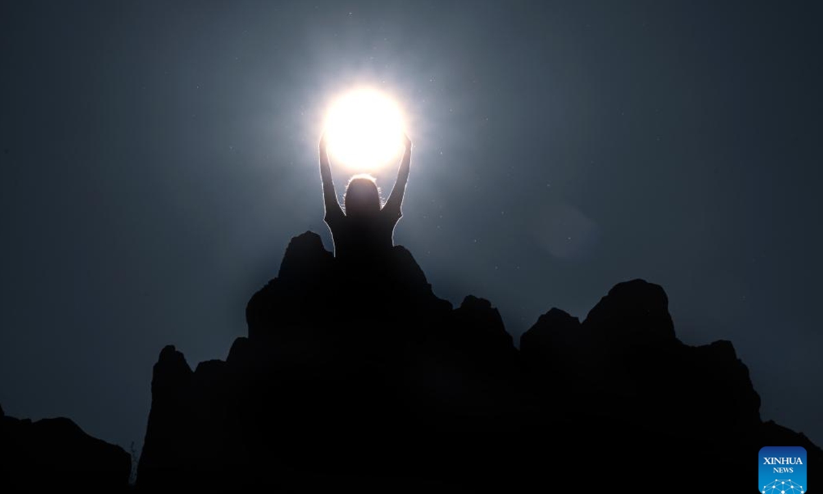 A person poses for a photo as the sun rises on the summer solstice at the ancient megalithic observatory of Kokino, North Macedonia, June 21, 2023. (Photo by Tomislav Georgiev/Xinhua)

