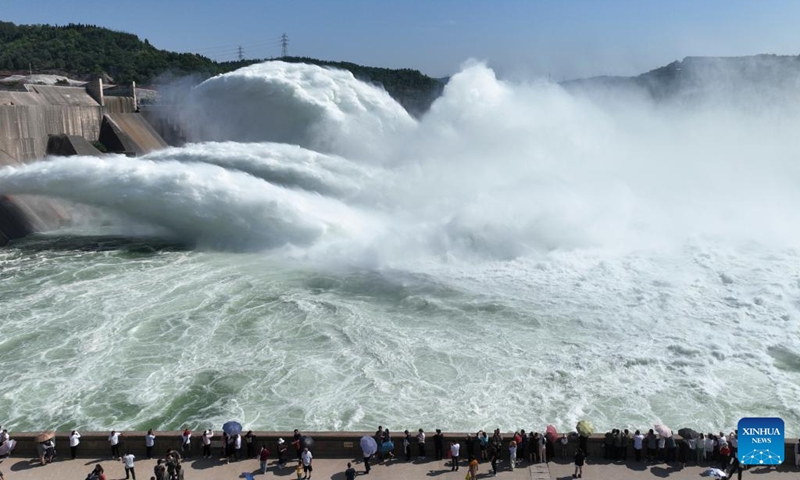 This aerial photo shows tourists watching water gushing out from the Xiaolangdi Reservoir on the Yellow River in central China's Henan Province, June 23, 2023. People go out for various activities during the three-day Dragon Boat Festival holiday across the country. (Photo by Miao Qiunao/Xinhua)