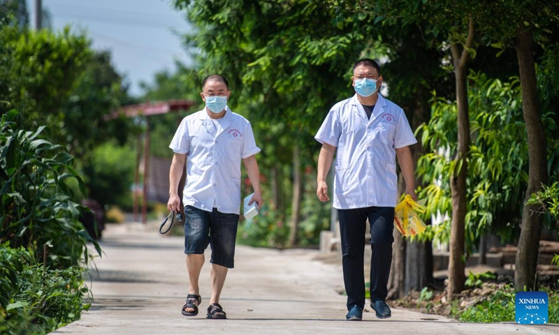 Medical workers walk to provide door-to-door health care service for senior residents at a community in Anxiang County of Changde City, central China's Hunan Province, June 21, 2023. The city of Changde has scaled up efforts to develop an elderly care service system composed mainly of in-home cares, community services, institutional and medical cares. (Xinhua/Chen Sihan)