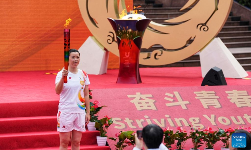 Torch bearer Li Xuerui holds the torch during the torch relay of the Chengdu 2021 FISU Summer World University Games at Chongqing University in southwest China's Chongqing Municipality, June 24, 2023. Photo: Xinhua