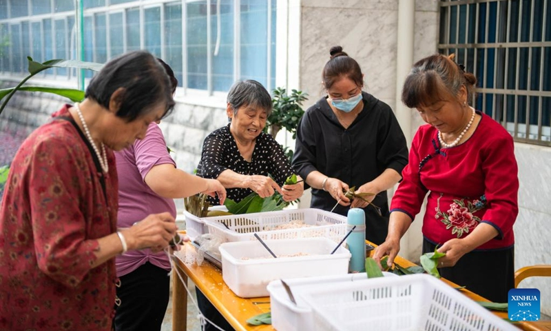 Senior residents make Zongzi, a pyramid-shaped dumpling made of glutinous rice wrapped in bamboo or reed leaves, at a nursing home in Hanshou County of Changde City, central China's Hunan Province, June 20, 2023. The city of Changde has scaled up efforts to develop an elderly care service system composed mainly of in-home cares, community services, institutional and medical cares. (Xinhua/Chen Sihan)