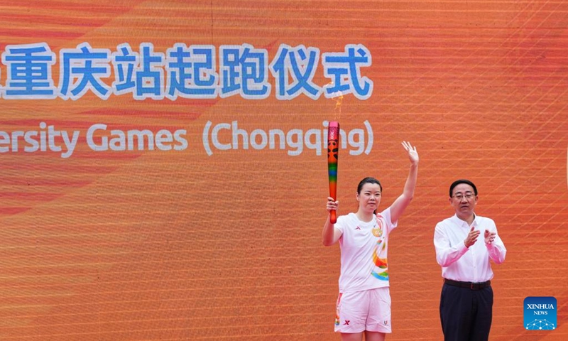 Torch bearer Li Xuerui (L) holds the torch during the torch relay of the Chengdu 2021 FISU Summer World University Games at Chongqing University in southwest China's Chongqing Municipality, June 24, 2023. Photo: Xinhua