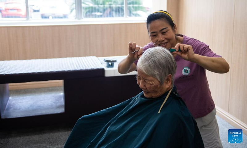 A staff member gives a haircut for a senior resident at a nursing home in Hanshou County of Changde City, central China's Hunan Province, June 20, 2023. The city of Changde has scaled up efforts to develop an elderly care service system composed mainly of in-home cares, community services, institutional and medical cares. (Xinhua/Chen Sihan)