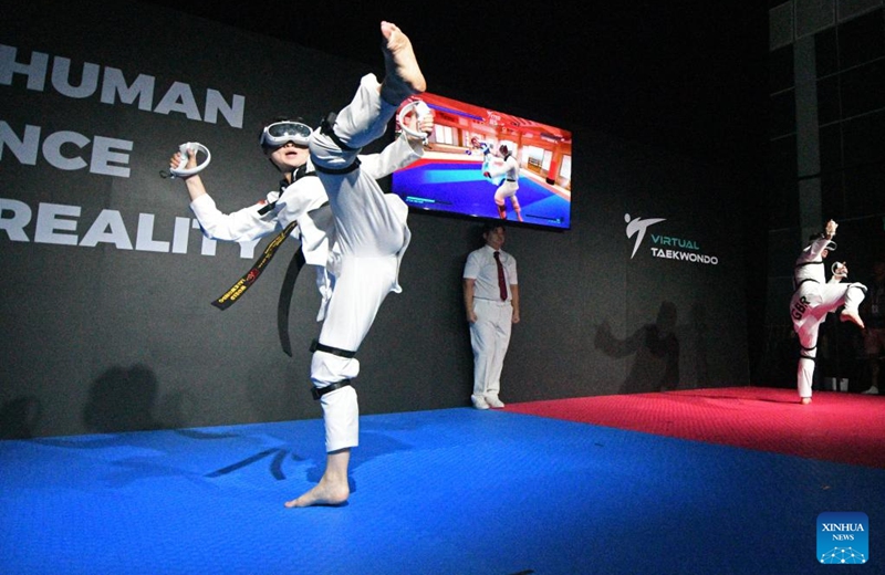 Wu Jingyu (L) of China competes during the first round of the taekwondo event against Aaron Cook of Great Britain at the Olympic ESports Week 2023 held in Singapore on June 23, 2023. (Photo by Then Chih Wey/Xinhua)