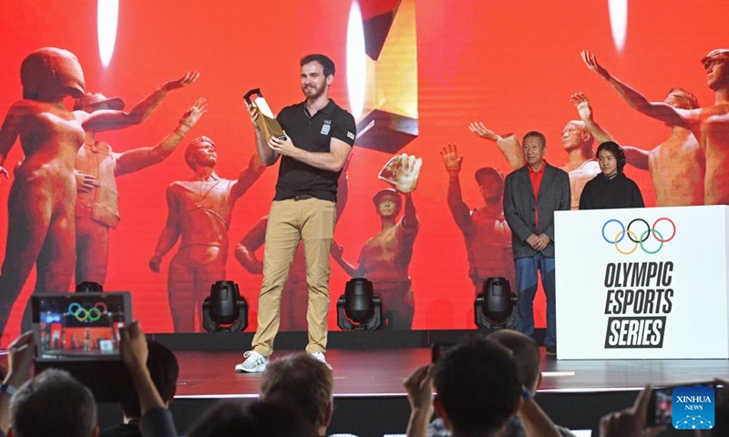 Jared Montgomery (L) of the United States celebrates with his trophy during the awarding ceremony after winning the archery event at the Olympic ESports Week 2023 held in Singapore on June 23, 2023. (Photo by Then Chih Wey/Xinhua)