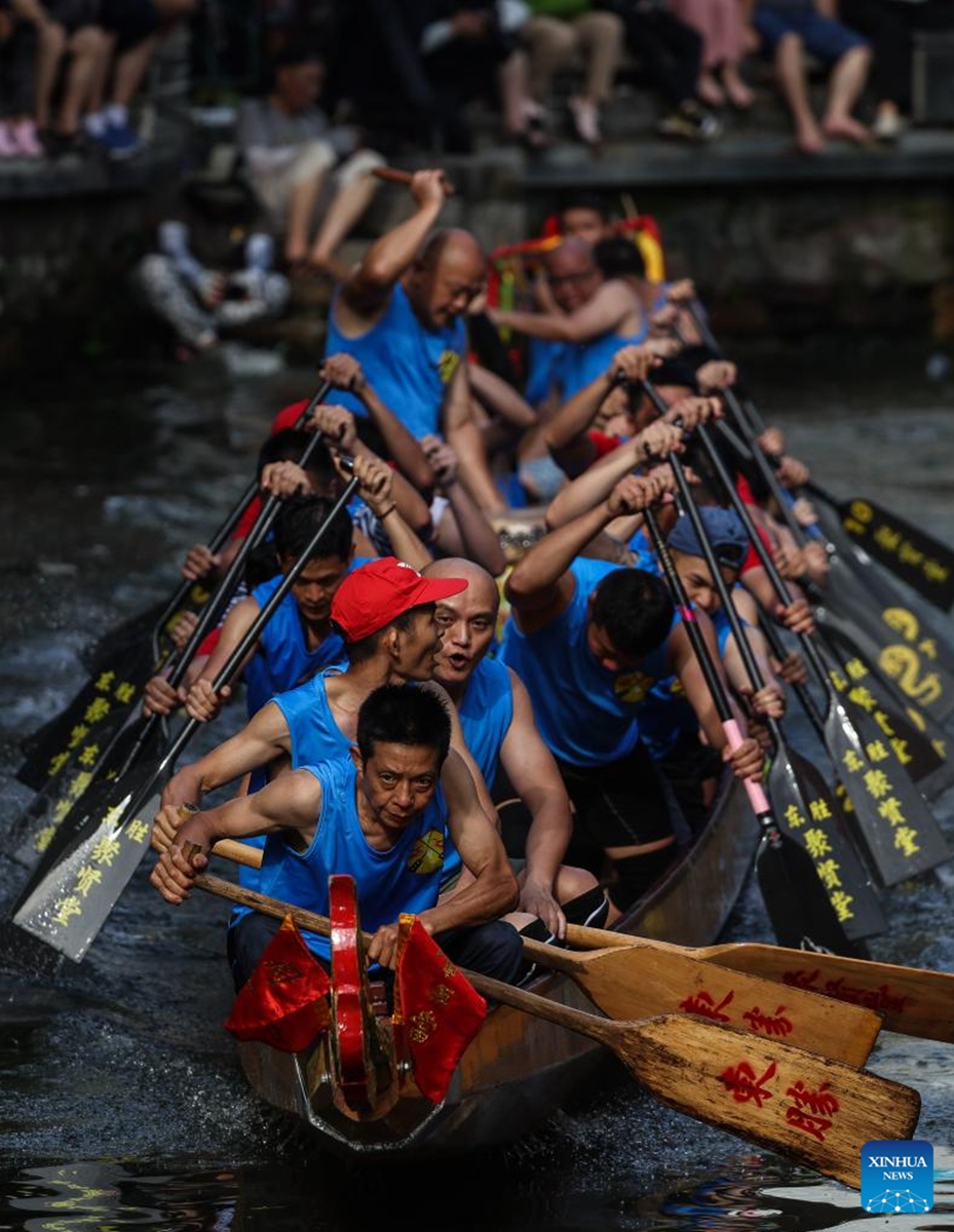 Participants take part in a dragon boat race in Diejiao Township of Foshan, south China's Guangdong Province, June 22, 2023. With a narrow and winding river, Diejiao Township holds the dragon boat race annually for the Dragon Boat Festival. Participants must drift the 25-meter-long vessel around shapes curved like S, C and L at full speed. (Xinhua/Liu Dawei)