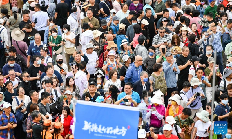 This photo shows tourists at the east gate of the ancient city of Kashgar scenic area in Kashgar, northwest China's Xinjiang Uygur Autonomous Region, June 14, 2023. (Xinhua/Hu Huhu)