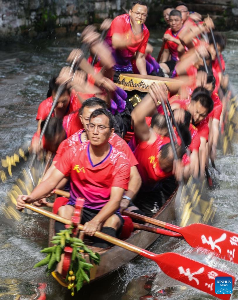 Participants take part in a dragon boat race in Diejiao Township of Foshan, south China's Guangdong Province, June 22, 2023. With a narrow and winding river, Diejiao Township holds the dragon boat race annually for the Dragon Boat Festival. Participants must drift the 25-meter-long vessel around shapes curved like S, C and L at full speed. (Xinhua/Liu Dawei)