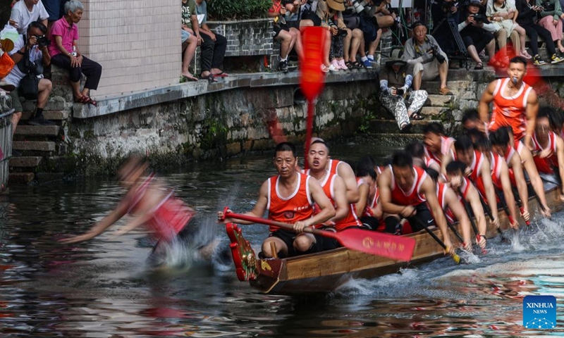 A participant falls off the dragon boat during a dragon boat race in Diejiao Township of Foshan, south China's Guangdong Province, June 22, 2023. With a narrow and winding river, Diejiao Township holds the dragon boat race annually for the Dragon Boat Festival. Participants must drift the 25-meter-long vessel around shapes curved like S, C and L at full speed. (Xinhua/Liu Dawei)