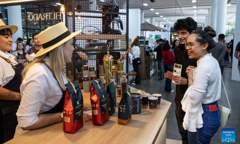 A staff member introduces products to visitors during the Sao Paulo Coffee Festival in Sao Paulo, Brazil, on June 23, 2023. (Xinhua/Wang Tiancong)