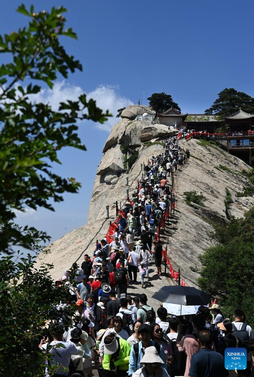 This photo taken on June 23, 2023 shows visitors on the Huashan Mountain in Weinan, northwest China's Shaanxi Province. (Photo by Zhang Lan/Xinhua)