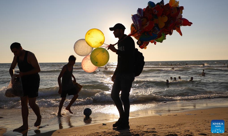 A vendor sells balloons at the beach of the Mediterranean sea amid a heatwave in Gaza City, on June 23, 2023. (Photo by Rizek Abdeljawad/Xinhua)