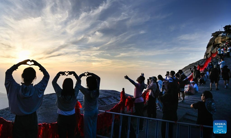 This photo taken on June 23, 2023 shows visitors enjoying sunset on the Huashan Mountain in Weinan, northwest China's Shaanxi Province. (Photo by Zhang Lan/Xinhua)