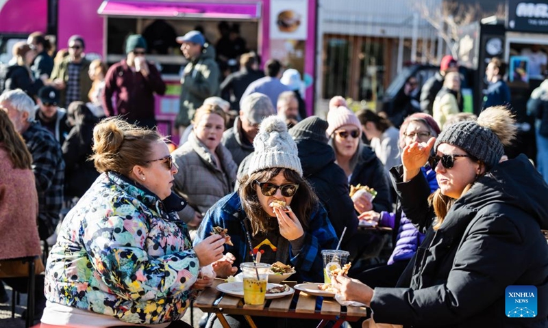 People attend a winter food festival in Canberra, Australia, on June 24, 2023. A winter food festival was held on Saturday to provide street food and other products by local cafes, food trucks, wineries and breweries for customers. (Photo by Chu Chen/Xinhua)