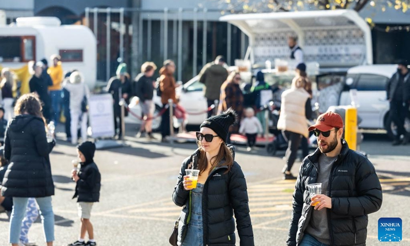 People attend a winter food festival in Canberra, Australia, on June 24, 2023. A winter food festival was held on Saturday to provide street food and other products by local cafes, food trucks, wineries and breweries for customers. (Photo by Chu Chen/Xinhua)