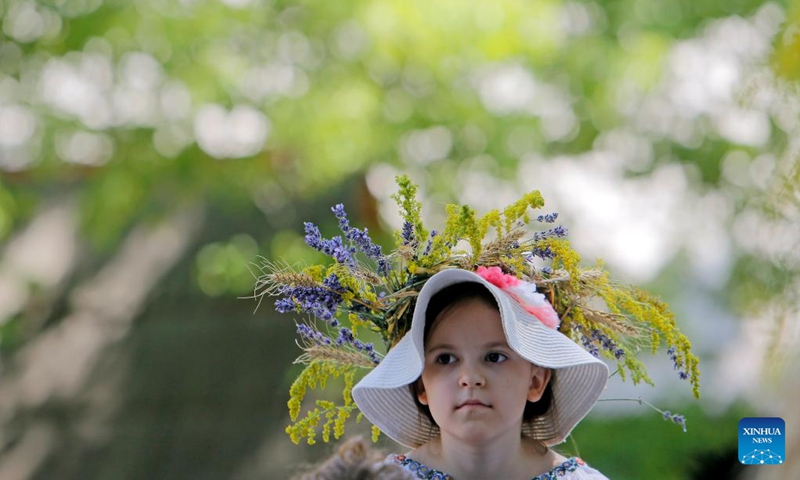 A young girl dressed as a fairy attends the traditional folk festival Sanziene in Bucharest, capital of Romania, June 24, 2023. Ancient traditions mention Sanzienele as gentle fairies that come around summer solstice to bring good luck and good harvest. (Photo by Cristian Cristel/Xinhua)