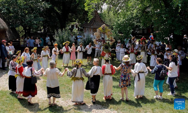 Visitors dance with young girls dressed as fairies during the traditional folk festival Sanziene in Bucharest, capital of Romania, June 24, 2023. Ancient traditions mention Sanzienele as gentle fairies that come around summer solstice to bring good luck and good harvest. (Photo by Cristian Cristel/Xinhua)