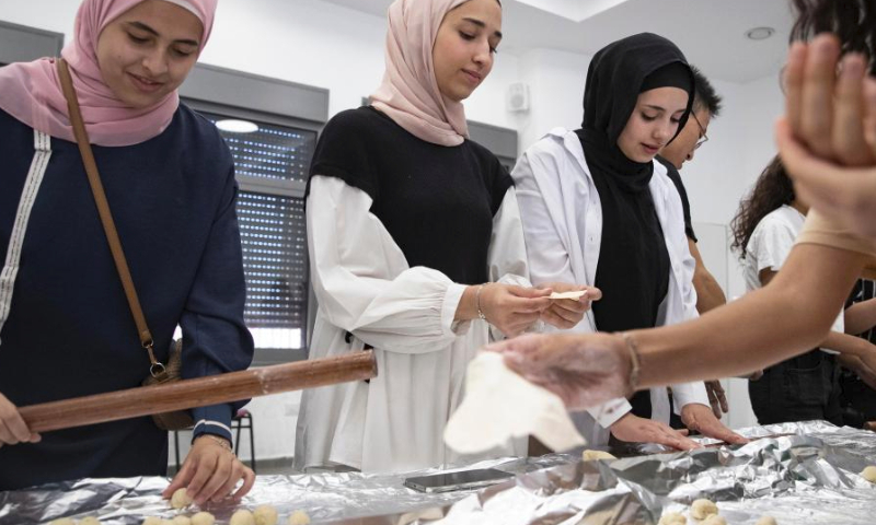 Students learn to make dumplings during a workshop to promote the broad and profound Chinese cuisine culture at an activity center in Wadi Joz, an Arab neighborhood in East Jerusalem, June 26, 2023. (Xinhua/Chen Junqing)