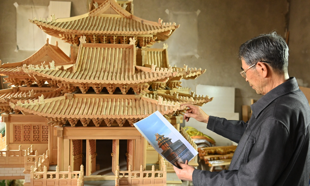 The 70-year-old craftsman makes a miniature version of the turret of the Forbidden City according to the picture in Yongchang county, Northwest China’s Gansu Province on June 27, 2023. Photo: IC