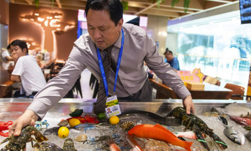 An exhibitor arranges African seafood products at the China-Africa Economic and Trade Cooperation Promotion Innovation Demonstration Park (Hunan Gaoqiao Grand Market) in Changsha, central China's Hunan Province, July 1, 2023. The third China-Africa Economic and Trade Expo is held in Changsha from June 29 to July 2. (Xinhua/Chen Sihan)