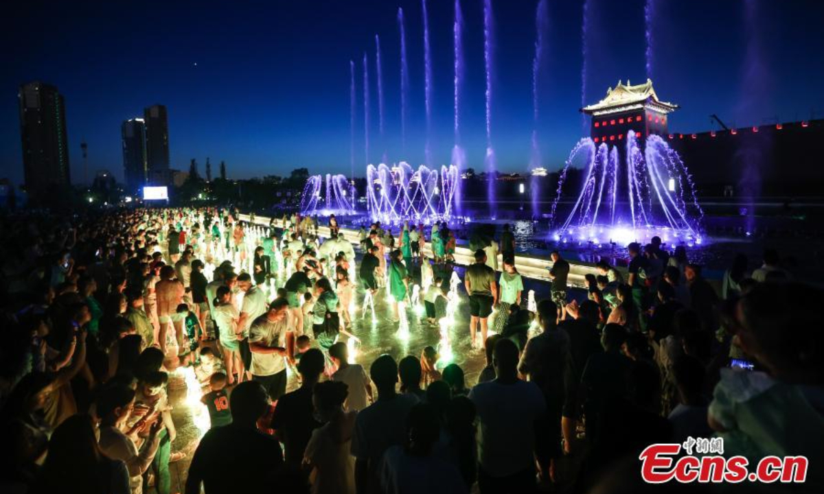 People beat the summer heat at night around a musical fountain in Datong, north China's Shanxi Province, June 29, 2023. Photo:Xinhua