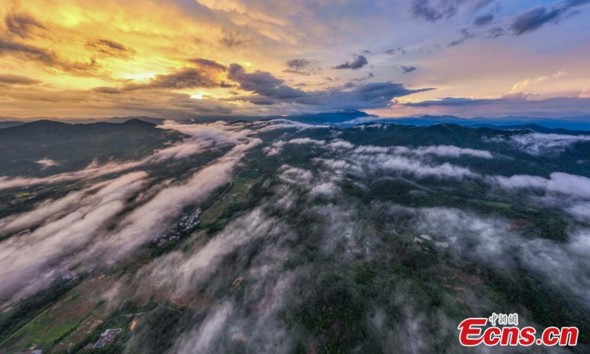 Wuzhi Mountain is shrouded by orange clouds at dusk at Hainan Tropical Rainforest National Park in south China's Hainan Province, June 29, 2023. Photo:China News Service