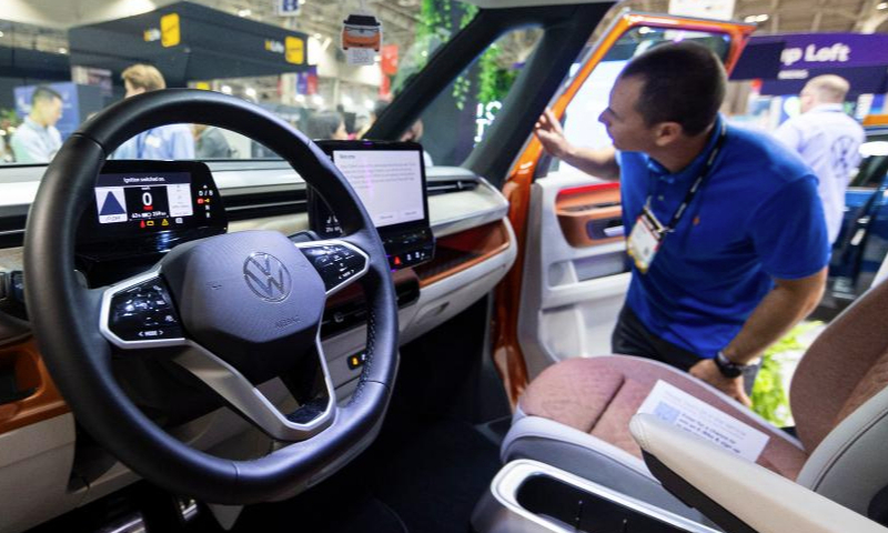 A man looks at a Volkswagen's electric vehicle ID. Buzz during the 2023 Collision Conference in Toronto, Canada, on June 27, 2023. The 2023 Collision Conference, an annual tech conference in North America, is held here from June 26 to June 29 this year. (Photo by Zou Zheng/Xinhua)