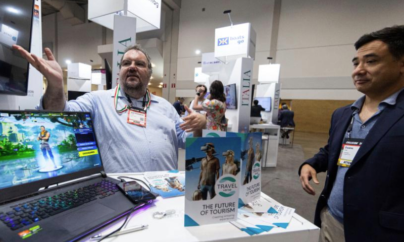 An exhibitor introduces a VR tourism project during the 2023 Collision Conference in Toronto, Canada, on June 27, 2023. The 2023 Collision Conference, an annual tech conference in North America, is held here from June 26 to June 29 this year. (Photo by Zou Zheng/Xinhua)