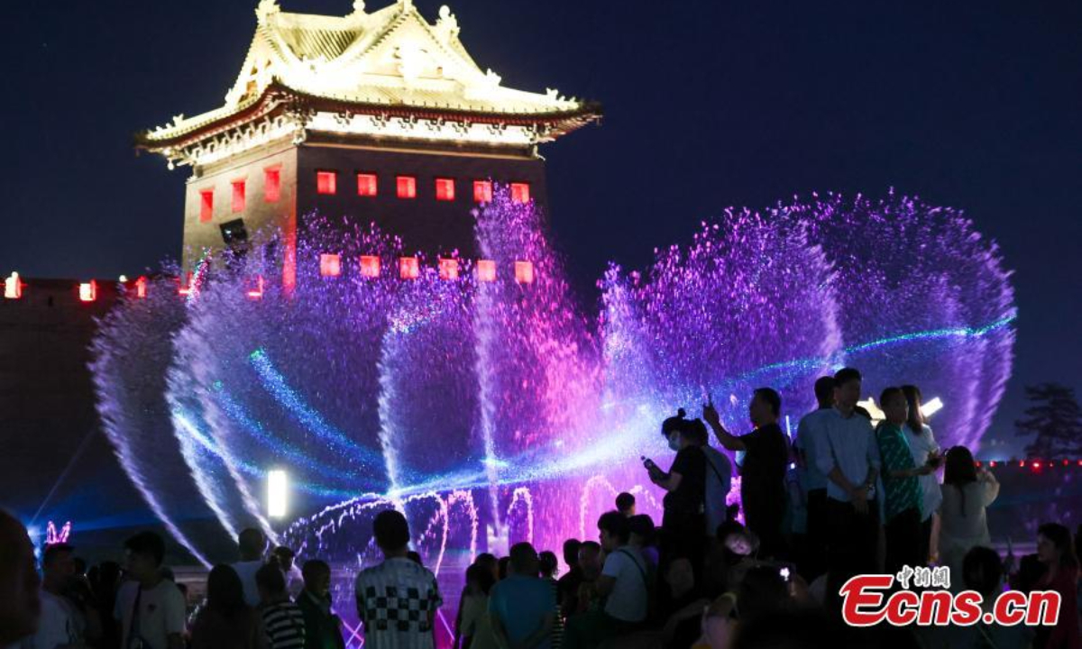 People beat the summer heat at night around a musical fountain in Datong, north China's Shanxi Province, June 29, 2023. Photo:Xinhua