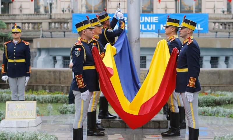 Soldiers hold the national flag during a ceremony marking Romania's National Flag Day in Bucharest, capital of Romania, June 26, 2023.(Photo: Xinhua)